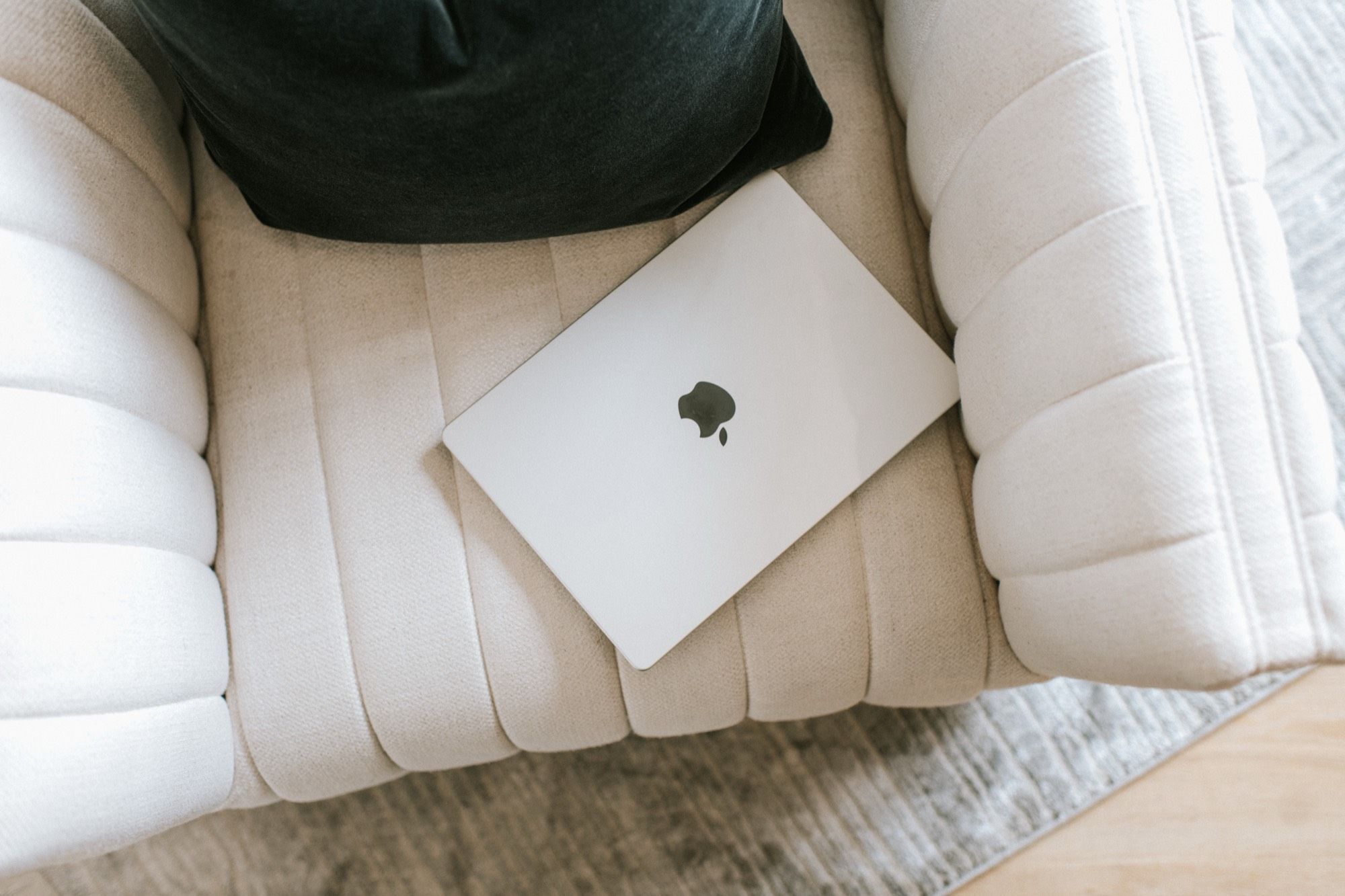 A laptop resting on a cream armchair